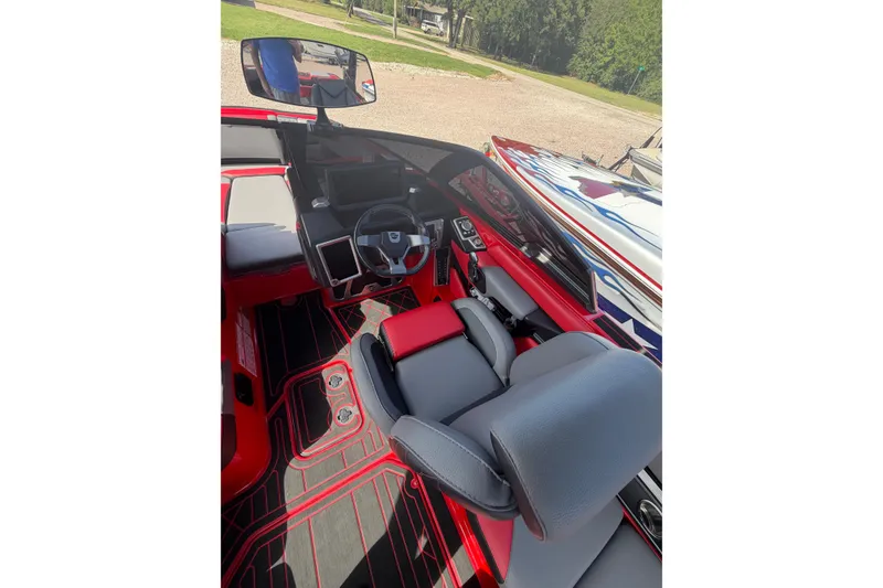 Slide: The Image of 2021 Malibu M220 boat interior with sleek red and gray design, featuring modern controls and seating. - 17