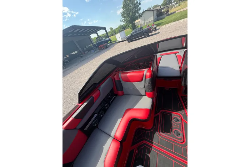 Slide: The Image of Interior of a 2021 Malibu M220 boat with red and gray seating. - 18