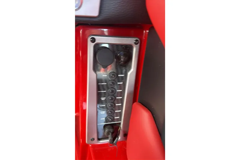 Slide: The Image of Control panel of a 2021 Malibu M220 boat with red and black interior. - 22