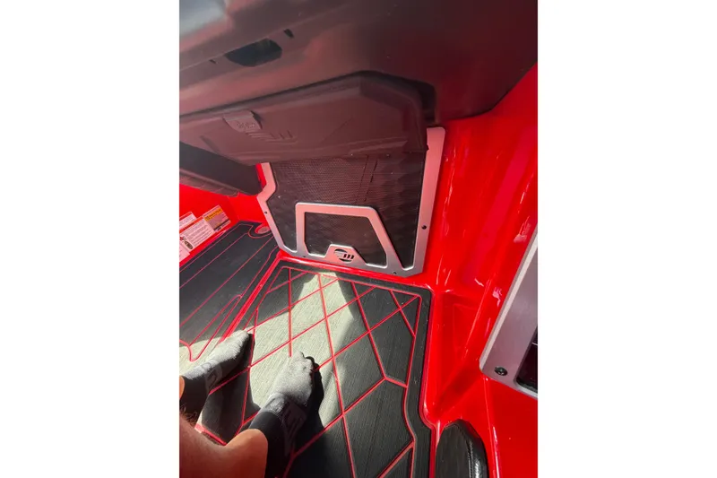 Slide: The Image of Interior of 2021 Malibu M220 boat with red and black flooring design. - 24