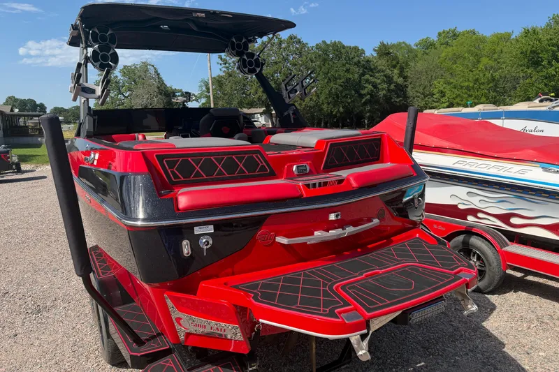 Slide: The Image of 2021 Malibu M220 boat in vibrant red, parked outdoors with sleek design and modern features. - 8