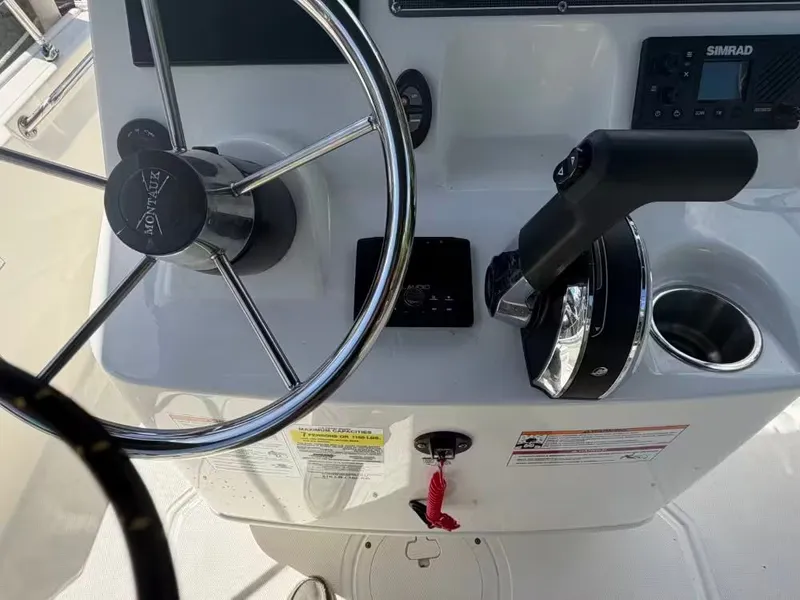 Slide: The Image of Boston Whaler 17 Montauk 2024 helm with steering wheel and throttle control. - 8