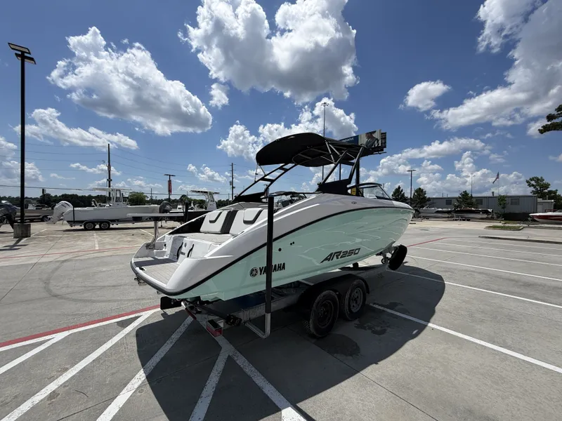 Slide: The Image of 2024 Yamaha AR250 boat on trailer under blue sky. - 8