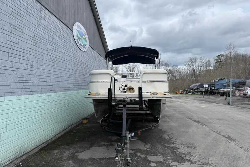 Slide: The Image of 2007 SunCatcher LX 22 SE pontoon boat on trailer, gray wall background. - 3