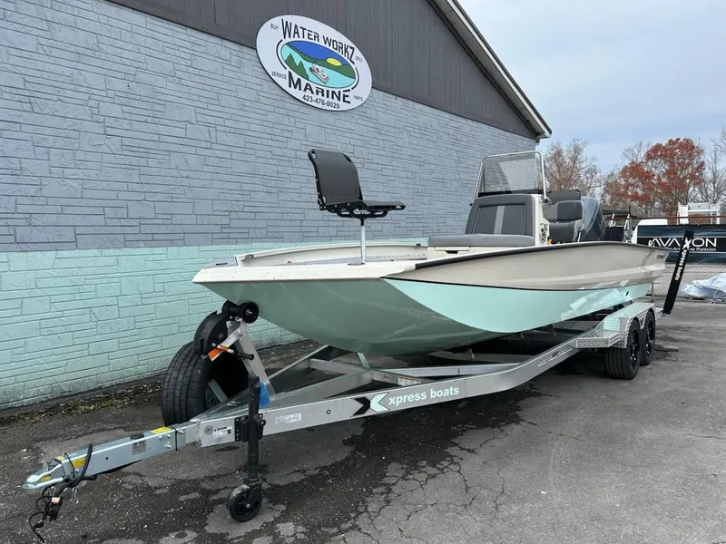 Slide: The Image of 2025 Xpress X23 Bay Lounge boat on trailer outside marine shop. - 2