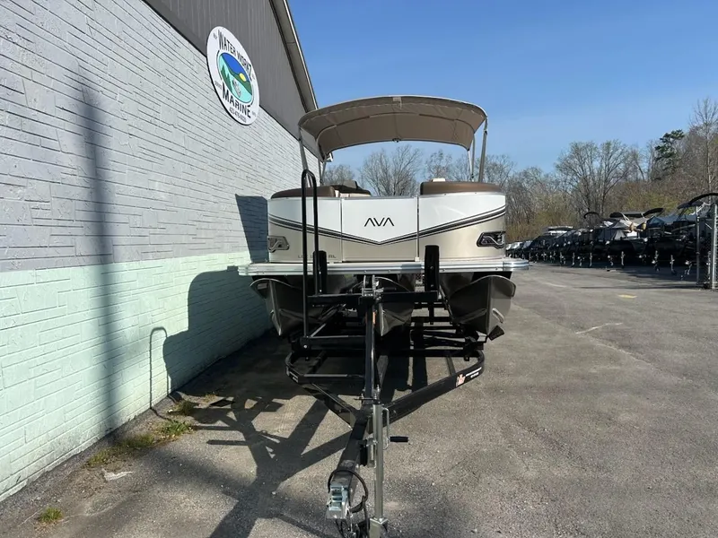 Slide: The Image of 2025 Avalon 2385 LSZ Rear Lounger pontoon boat in front of a building. - 3