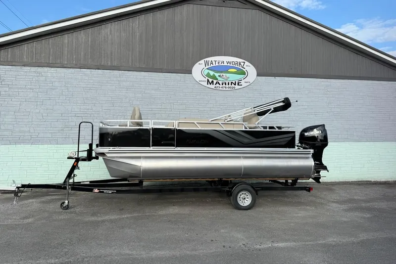 The Image of 2025 Avalon VTX Quad Fish pontoon boat outside marine shop. - 1