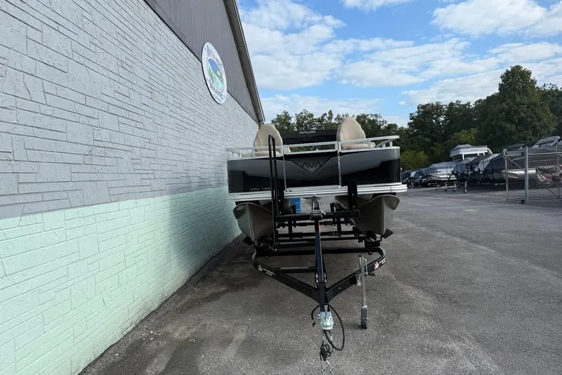 Slide: The Image of 2025 Avalon VTX Quad Fish boat on trailer outside building. - 3