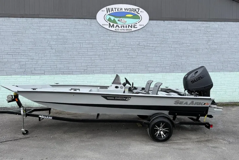 The Image of 2026 SeaArk Shadow 18 boat with Suzuki engine outside marine shop. - 1