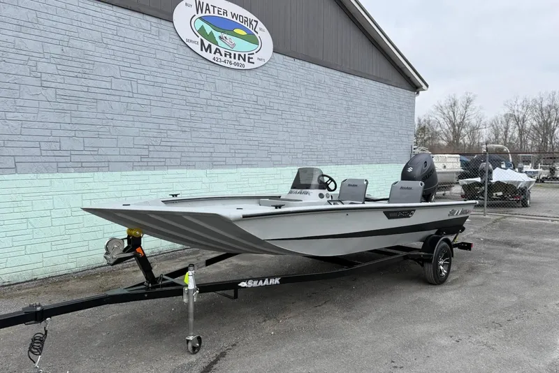 Slide: The Image of 2026 SeaArk Shadow 18 boat parked outside marine shop. - 2