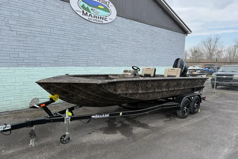 Slide: The Image of 2026 SeaArk Phantom 20XV boat on trailer outside marine shop. - 2