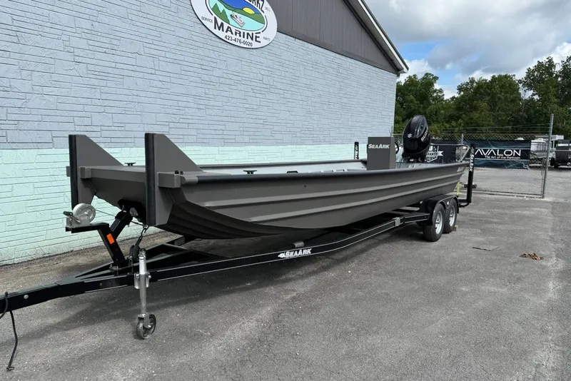 Slide: The Image of 2025 SeaArk 2472 Workhorse boat on trailer outside building. - 2