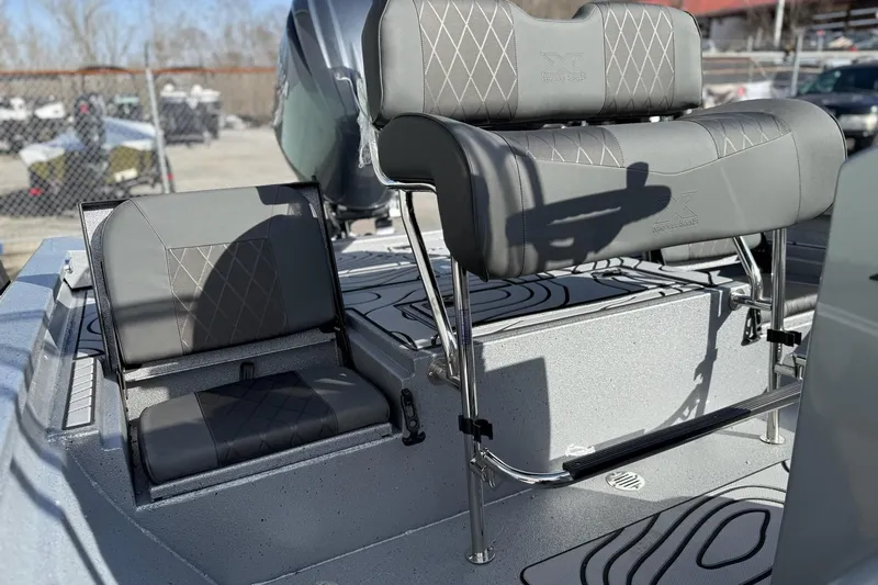 Slide: The Image of 2026 Xpress H20B Bay boat with gray seating outdoors. - 12