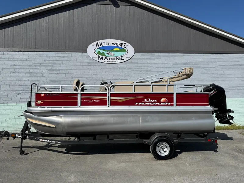 The Image of 2023 Sun Tracker Bass Buggy 18 DLX pontoon boat in front of marine building. - 1