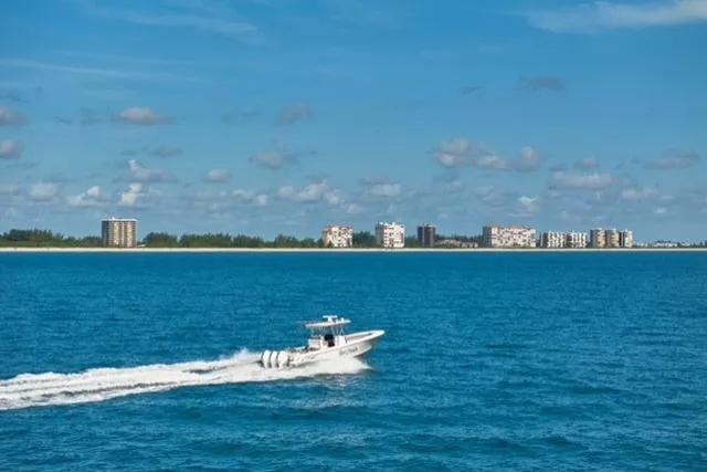Slide: The Image of Bluewater 355e boat cruising on ocean near coastal cityscape, 2022 model. - 14