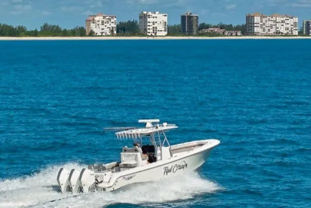 Slide: The Image of 2022 Bluewater 355e boat cruising on blue ocean with city skyline in background. - 8