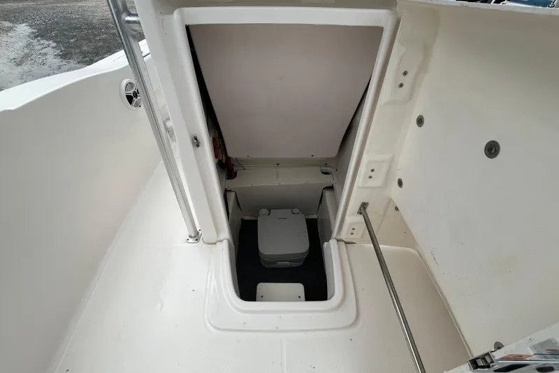 Slide: The Image of 2020 Robalo R200 Center Console boat interior with storage compartment and portable toilet. - 13