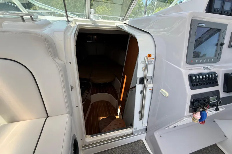 Slide: The Image of 2007 Robalo R305 Walkaround cabin entrance with control panel and seating area. - 10