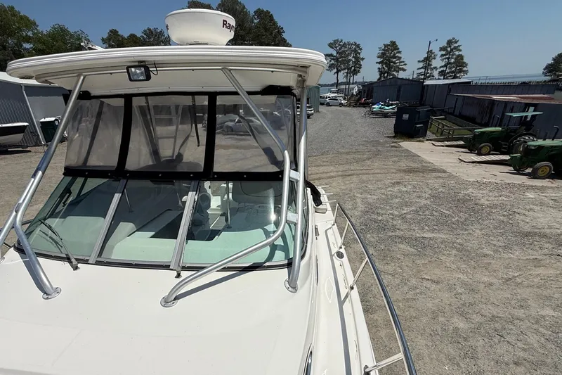 Slide: The Image of 2007 Robalo R305 Walkaround boat docked in a marina with clear skies. - 13
