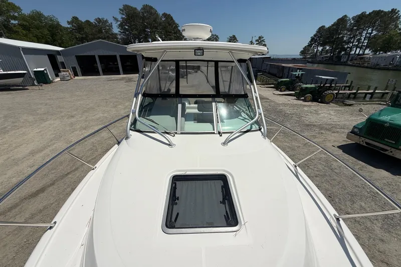 Slide: The Image of 2007 Robalo R305 Walkaround boat docked, showcasing spacious deck and windshield. - 14