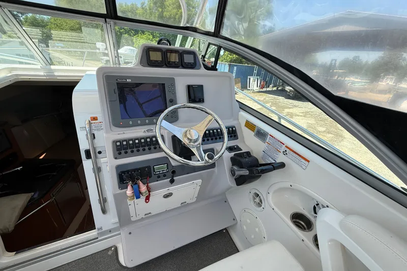 Slide: The Image of 2007 Robalo R305 Walkaround helm with steering wheel and navigation controls. - 19