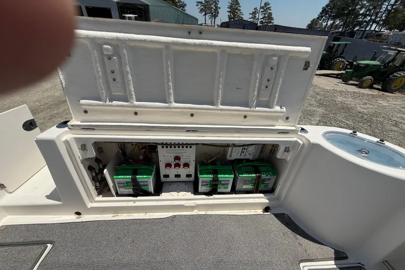 Slide: The Image of 2007 Robalo R305 Walkaround boat battery compartment with multiple batteries and control panel. - 20