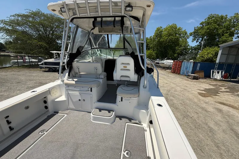 Slide: The Image of 2007 Robalo R305 Walkaround boat interior with seating and storage, docked outdoors. - 22