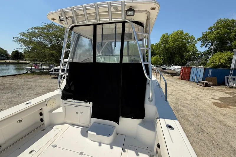 Slide: The Image of 2007 Robalo R305 Walkaround boat with covered cockpit, docked near a marina. - 5