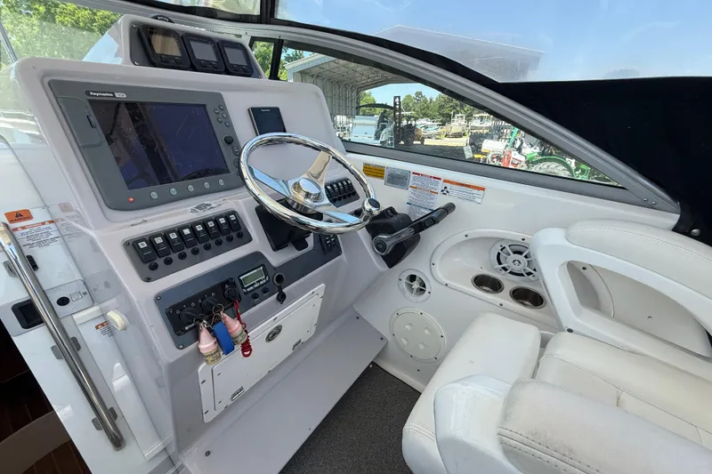 Slide: The Image of 2007 Robalo R305 Walkaround helm with steering wheel, navigation controls, and white seating. - 6