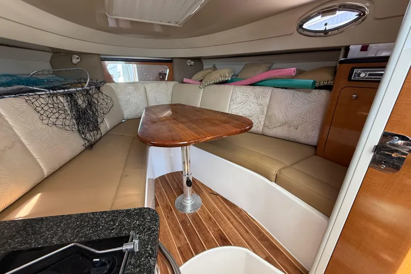 Slide: The Image of Interior of 2007 Robalo R305 Walkaround boat with seating and wooden table. - 7