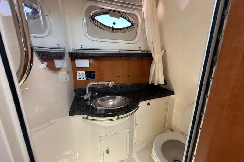 Slide: The Image of 2007 Robalo R305 Walkaround boat bathroom with sink, mirror, and toilet. - 8