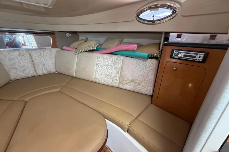 Slide: The Image of 2007 Robalo R305 Walkaround cabin interior with beige seating and wood accents. - 9