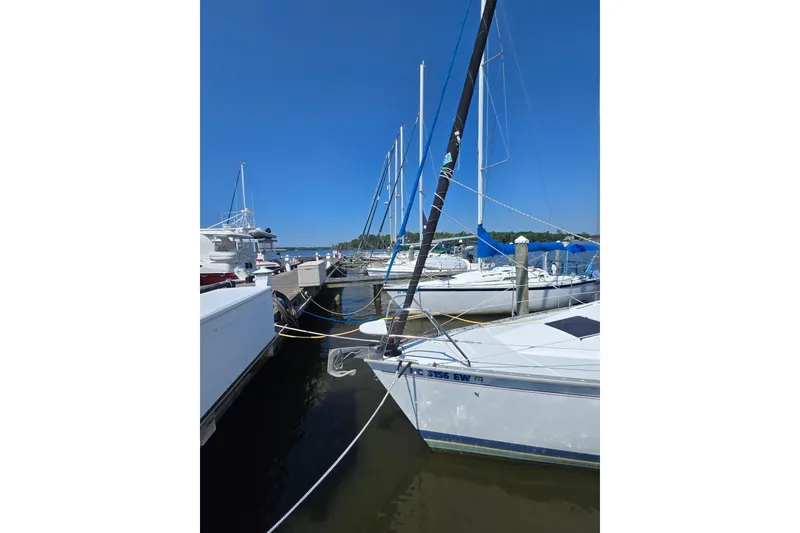 Slide: The Image of Sailboats docked at marina, featuring a 1993 Hunter Legend 35.5 under clear blue sky. - 6