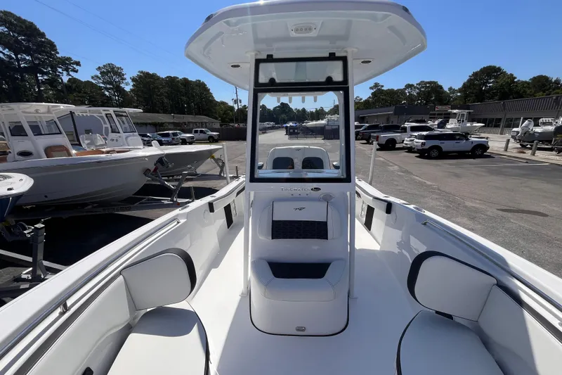 Slide: The Image of 2026 Tidewater 220 CC Adventure boat interior, showcasing seating and console design at a marina. - 11