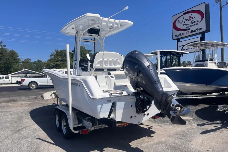 Slide: The Image of 2026 Tidewater 220 CC Adventure boat on trailer at dealership, featuring powerful outboard motor. - 2