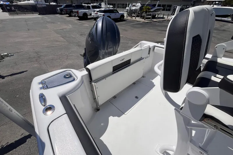 Slide: The Image of 2026 Tidewater 220 CC Adventure boat interior with seating and motor in a parking lot. - 5