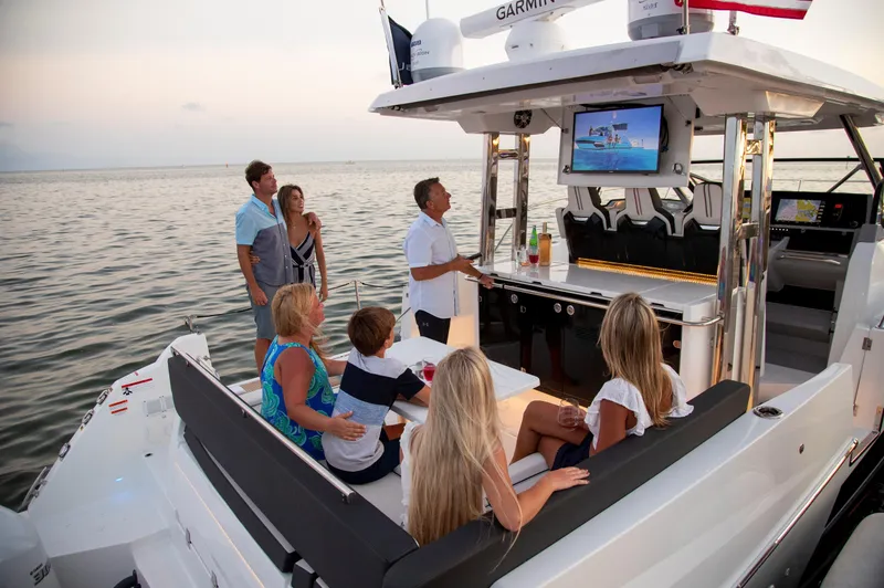 Slide: The Image of 2024 Jeanneau Leader 12.5 WA boat with people enjoying a sunset cruise. - 12