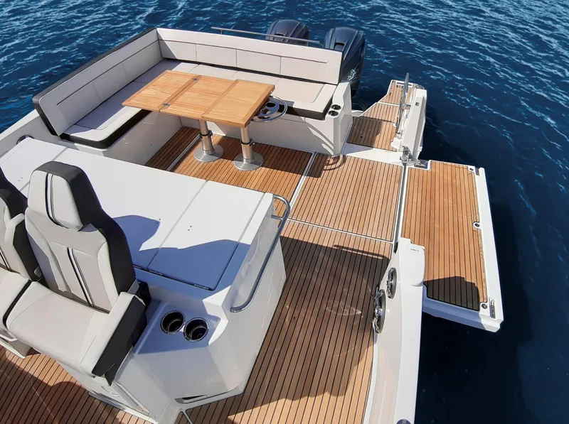 Slide: The Image of 2024 Jeanneau Leader 12.5 WA boat with spacious deck and seating area on water. - 8