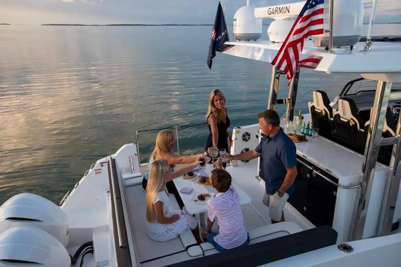 Slide: The Image of 2024 Jeanneau Leader 12.5 WA boat with people enjoying a meal on deck. - 9