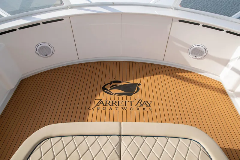 Slide: The Image of Luxury Jarrett Bay 84 yacht deck, 2020 model, featuring elegant wood finish and logo. - 43