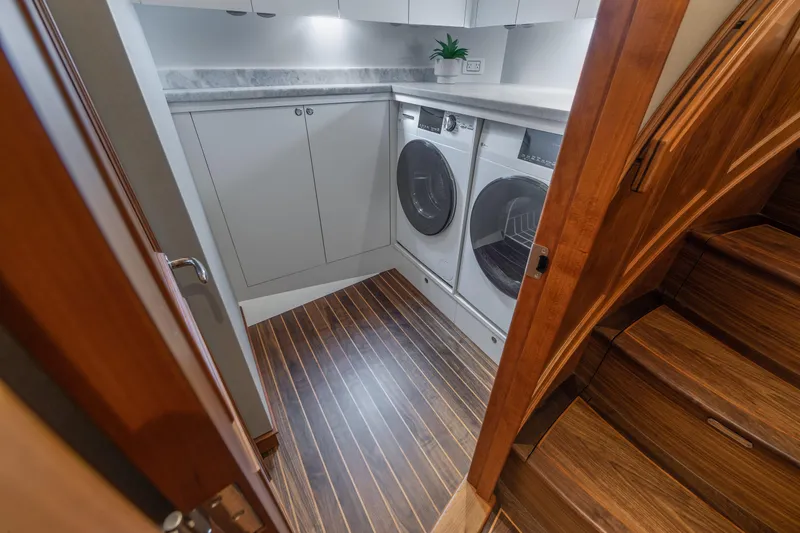 Slide: The Image of Laundry room on 2020 Jarrett Bay 84 yacht with washer, dryer, and wooden flooring. - 67