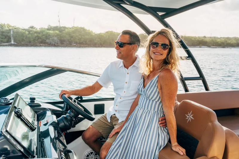 Slide: The Image of Couple enjoying a ride on a 2026 Jeanneau TH33 boat, smiling and relaxed. - 12
