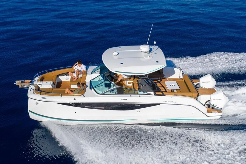 Slide: The Image of Manufacturer Provided Image: 2026 Jeanneau TH33 motorboat cruising on open water with passengers onboard. - 2