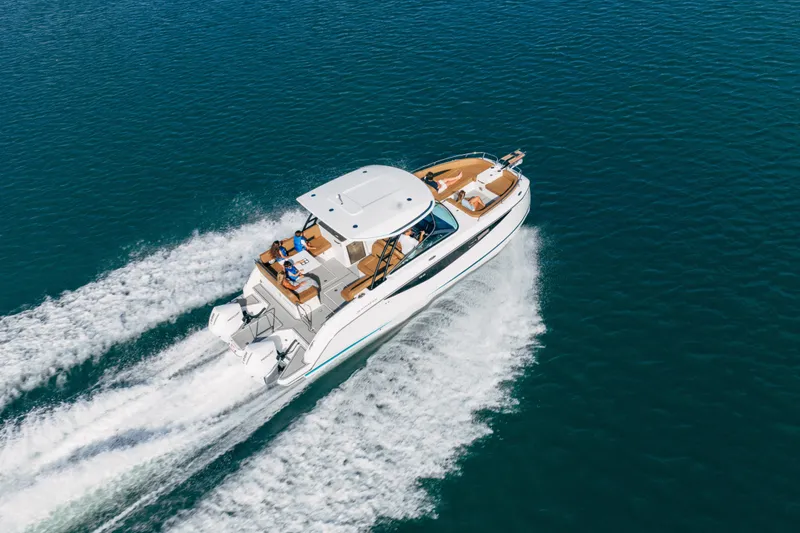 Slide: The Image of 2026 Jeanneau TH33 motorboat cruising on open water, aerial view. - 5