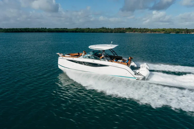 Slide: The Image of 2026 Jeanneau TH33 motorboat cruising on open water under a partly cloudy sky. - 6