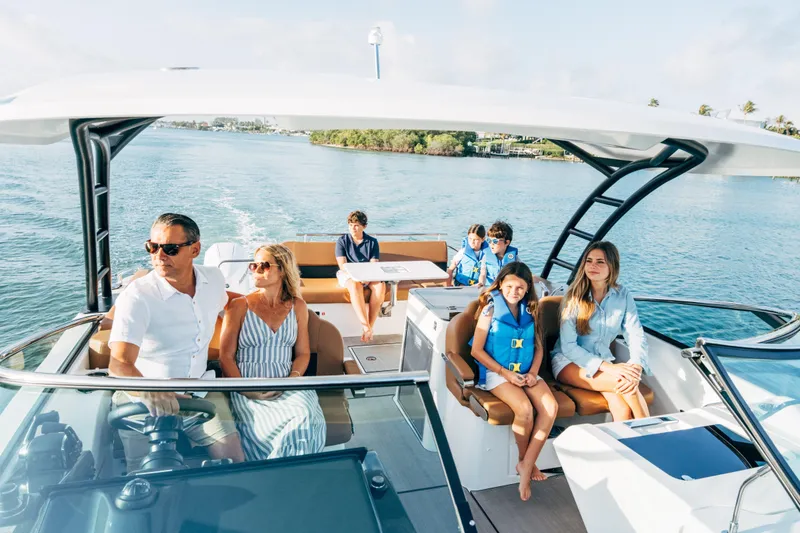 Slide: The Image of Family enjoying a sunny day on a 2026 Jeanneau TH33 boat. - 7