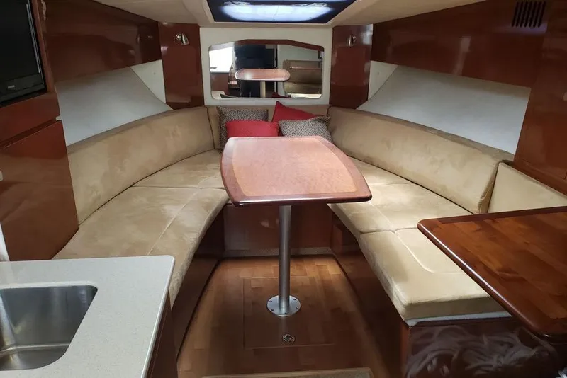 Slide: The Image of Luxurious interior of 2010 Sea Ray Sundancer 310 yacht with plush seating and wooden table. - 4