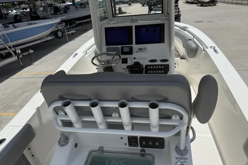 Slide: The Image of 2021 NauticStar 2602 Legacy boat interior with helm, rod holders, and navigation screens. - 10