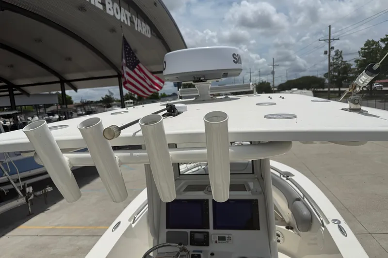 Slide: The Image of 2021 NauticStar 2602 Legacy boat with rod holders and radar, docked at a boatyard. - 11