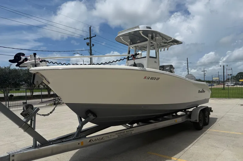 Slide: The Image of 2021 NauticStar 2602 Legacy boat on trailer under cloudy sky. - 4